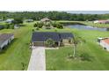 Aerial view of a home with a large yard, a pond, shed, and mature landscaping at 3600 Fountainbleu Blvd, Kissimmee, FL 34746