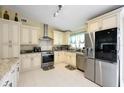 Well-lit kitchen featuring stainless steel appliances, white cabinetry, and tile flooring at 3600 Fountainbleu Blvd, Kissimmee, FL 34746