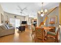 Inviting living room with hardwood floors, ceiling fan, chandelier, staircase and open floor plan at 3725 Calabria Ave, Davenport, FL 33897