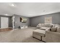 Spacious living room with plush sectional sofa, neutral carpet, and a wall-mounted TV at 391 Begonia Ct, Kissimmee, FL 34759