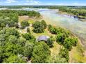 Aerial view showcases a cozy home with a pool, surrounded by lush green trees and vegetation at 4055 State Road 11, Deland, FL 32724