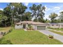 This home boasts a well-manicured lawn, craftsman architecture, and mature trees at 4770 Drummond Ln, Orlando, FL 32810