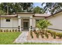 Detailed view of the front entrance showcasing lush plants, a brick pathway, and a modern aesthetic at 4770 Drummond Ln, Orlando, FL 32810