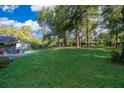 Expansive backyard with lush green grass and mature trees, perfect for outdoor activities at 493 Princewood Dr, Deland, FL 32724