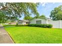 Well-maintained home showcasing a lush green lawn and neat landscaping, complemented by a white picket fence at 4963 Hoperita St, Orlando, FL 32812