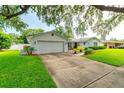 Attractive single-story home with a spacious driveway, lush lawn, and inviting front porch at 4963 Hoperita St, Orlando, FL 32812