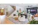 Bright and airy living room featuring hardwood floors, a staircase, and stylish furnishings at 5351 Carson St, St Cloud, FL 34771