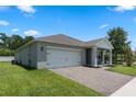 Well-maintained home showcasing a paved driveway, two-car garage, and lush green lawn at 5515 Palomino Pl, Apopka, FL 32712