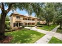Charming two-story home featuring a tile roof, balcony, with mature trees and a manicured lawn at 6149 Blakeford Dr, Windermere, FL 34786