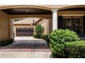 Portico with brick driveway, view of garage, mature shrubbery, and basketball hoop at 6149 Blakeford Dr, Windermere, FL 34786