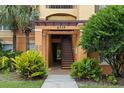Condo building entrance featuring well-kept landscaping, stairs, and clearly marked unit numbers for easy access at 6335 Contessa Dr # 208, Orlando, FL 32829