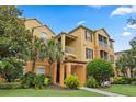 Attractive condo building showcasing well-maintained landscaping and classic architectural details under a blue sky at 6335 Contessa Dr # 208, Orlando, FL 32829