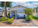 Charming single-story home featuring a well-manicured front yard, vibrant plants, and covered porch seating at 9000 Us Highway 192 # 115, Clermont, FL 34714