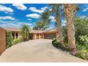Long driveway with mature palms that leads to a well-maintained home with an attached garage at 119 Rock Lake Rd, Longwood, FL 32750