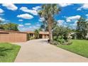 Long driveway leading to a well-maintained home with lush landscaping, including mature palm trees at 119 Rock Lake Rd, Longwood, FL 32750