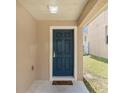 Welcoming front entry featuring a stylish dark blue door with elegant hardware and a neutral-toned exterior at 126 San Carlo Rd, Davenport, FL 33896