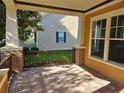 Covered front porch showcasing brick flooring and accents with classic column architecture at 1414 Stickley Ave, Kissimmee, FL 34747