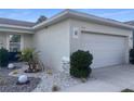View of two car garage with decorated garden bed at 1418 Kissimmee Ct, Kissimmee, FL 34759