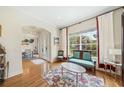 Cozy living room featuring hardwood floors, large window, and an archway leading to the formal dining room at 1420 Palmer Ave, Winter Park, FL 32789