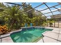 Sparkling screened-in pool with a spa and lush landscaping at 1429 Arbitus Cir, Oviedo, FL 32765