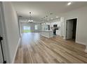 Bright, open-concept living space with wood-look floors and a modern kitchen island at 16463 Sw 55Th Court Rd, Ocala, FL 34473
