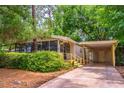 Cozy home with a screened-in porch and carport, surrounded by mature landscaping for added privacy at 203 N Forest Blvd, Lake Mary, FL 32746