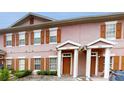 Charming townhome featuring a symmetrical facade, brown shutters, and private front entrances with white pillars at 2411 Caravelle Cir, Kissimmee, FL 34746