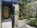 Inviting front entrance with yellow door, black iron gate, and lush landscaping at 2426 Windward Way, Winter Park, FL 32792