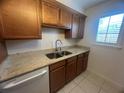 Functional kitchen with granite countertop, stainless steel sink, wood cabinets and a window for natural light at 2426 Windward Way, Winter Park, FL 32792