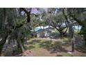 Charming home exterior featuring lush landscaping, mature trees, and serene setting at 2518 Fort Lane Rd, Geneva, FL 32732