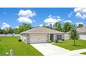 Inviting single-story home with a manicured lawn, features an attached garage and clean design at 2668 Grand Central Ave, Tavares, FL 32778