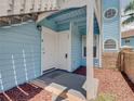 Blue condo entryway with a decorative welcome mat and red rock landscaping at 2729 N Poinciana Blvd # 125, Kissimmee, FL 34746
