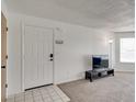 Entryway view of the carpeted living room with TV, lamp, and front door at 2729 N Poinciana Blvd # 125, Kissimmee, FL 34746