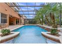 Relaxing backyard pool area featuring a screened enclosure, tropical landscaping, and an outdoor seating area at 2828 Northampton Ave, Orlando, FL 32828