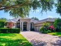 Beautiful one-story home with a brick driveway, well-kept lawn, and mature landscaping for added curb appeal at 3216 Rolling Hills Ln, Apopka, FL 32712