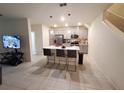Open-concept kitchen featuring a modern island with seating, pendant lights, and stainless steel appliances at 3316 Bellissimo Ave, Kissimmee, FL 34746