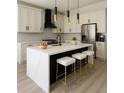 Bright, modern kitchen featuring white cabinets, a spacious island with seating, and stainless steel appliances at 3325 W Washington St, Orlando, FL 32805