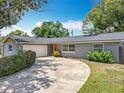One-story home with an attached garage and a curved driveway, nestled in a well-landscaped front yard at 3443 Arnel Dr, Winter Park, FL 32792