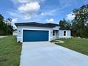 Charming single-story home with a blue garage door and long concrete driveway at 529 Marion Oaks Ln, Ocala, FL 34473