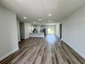 Bright, open-concept living room with modern wood flooring and a view of the kitchen at 529 Marion Oaks Ln, Ocala, FL 34473