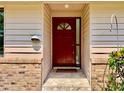 Inviting entryway featuring a red front door, tiled steps, and brick accents at 5724 Pitch Pine Dr, Orlando, FL 32819