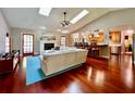 Open-concept living room featuring hardwood floors, skylights, and a seamless transition to the kitchen at 5724 Pitch Pine Dr, Orlando, FL 32819
