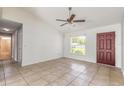 Open-concept living room featuring tile floors, a ceiling fan, and a view to the entrance door at 620 Unabelle Ave, Holly Hill, FL 32117