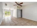 Bright living room with tile flooring, ceiling fan, and sliding glass doors to the backyard at 620 Unabelle Ave, Holly Hill, FL 32117