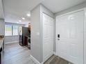 Bright entryway featuring light gray walls, wood-look floors, and a view into the updated kitchen at 7911 Murcott Cir, Orlando, FL 32835