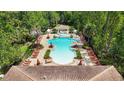 Resort-style pool with lounge chairs, umbrellas, and lush greenery in a gated community at 8219 Roseville Blvd, Davenport, FL 33896