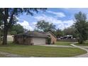 Brick home with a two-car garage, side lawn, and a driveway, offering a glimpse of the neighborhood at 900 Red Fox Rd, Altamonte Springs, FL 32714