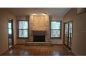 Bright living room featuring a brick fireplace, hardwood floors, and abundant natural light at 900 Red Fox Rd, Altamonte Springs, FL 32714