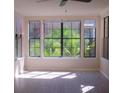 Sun-filled living room featuring neutral walls, hardwood floors, and a large window with a ceiling fan at 911 N Orange Ave # 335, Orlando, FL 32801