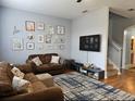 Cozy living room featuring hardwood floors, neutral paint and decor, and stairway to the second floor at 1022 Calabria Ave, Davenport, FL 33897